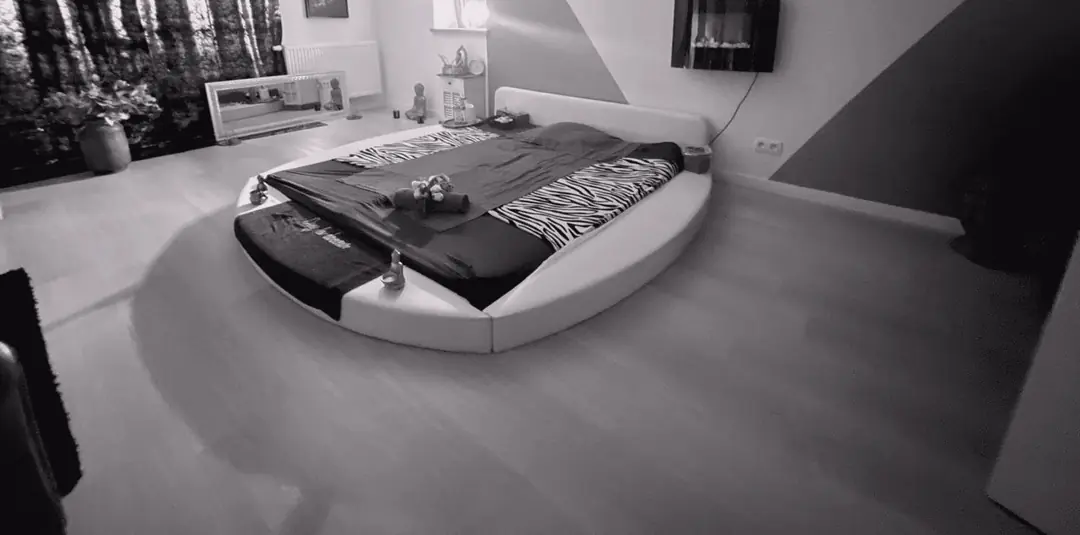 Une cabine avec un grand lit rond et une cheminée murale.