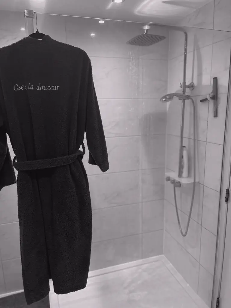 Un peignoir suspendu dans la salle de douche.